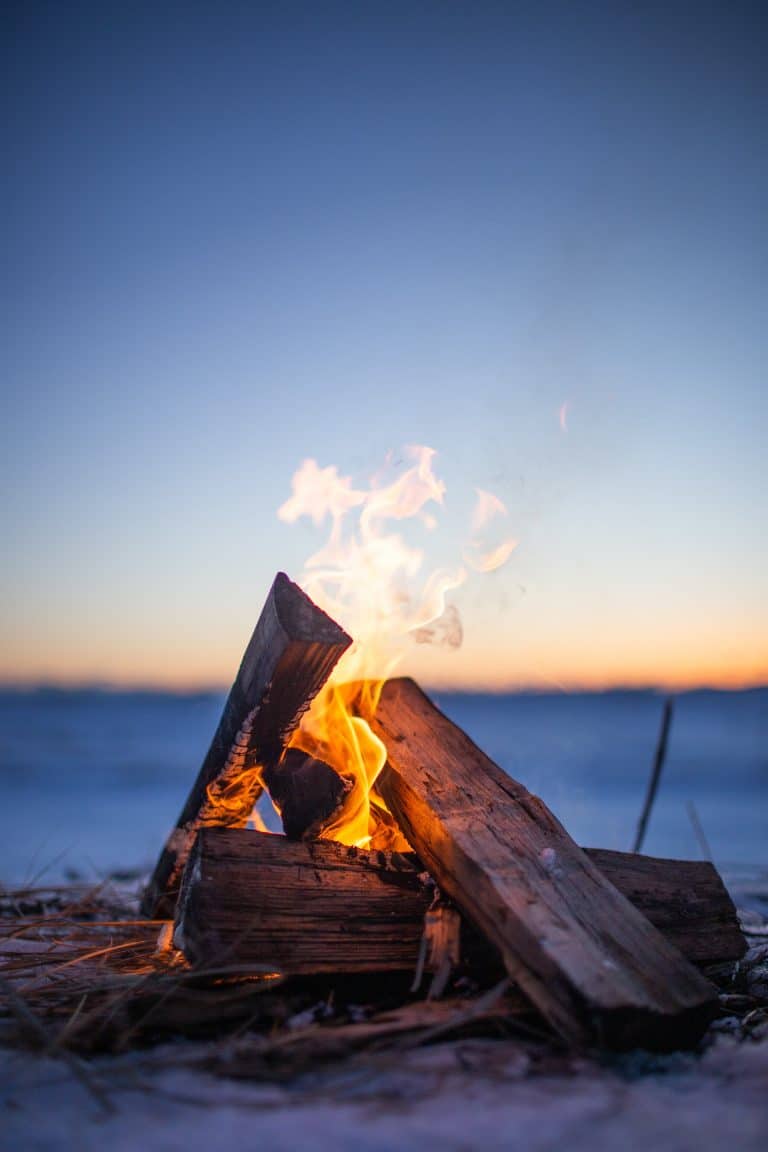 feu de camp au bord de la plage au coucher du soleil