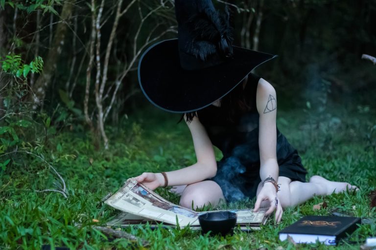 sorcière en train de lire son grimoire dans la nature